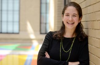 professor elsa olivetti leaning on wall